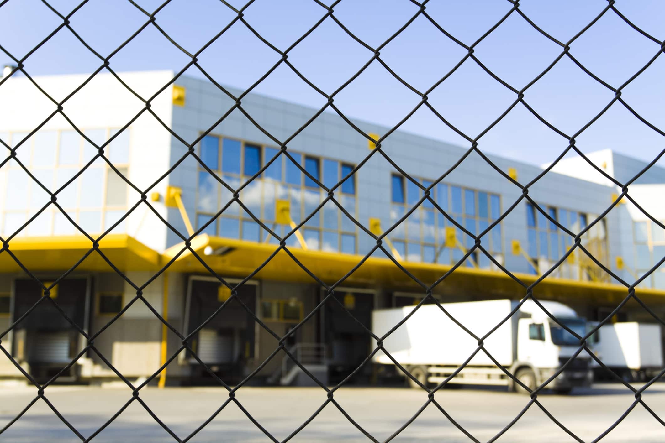 modern logistic center with chain link fence